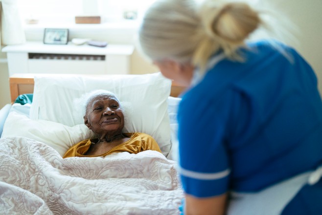 Nurse talking to a patient in bed