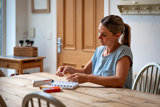 A woman sitting at a table with medication