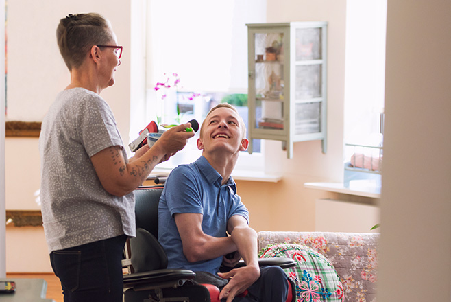 A man in a wheelchair talking to a caregiver