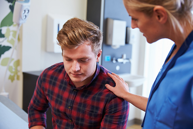 A nurse putting her hand on a man's shoulder