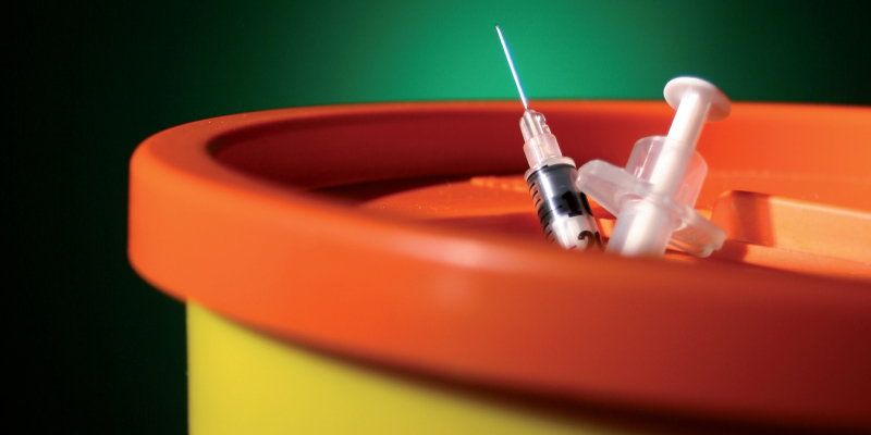 Sharps bin with needle on top